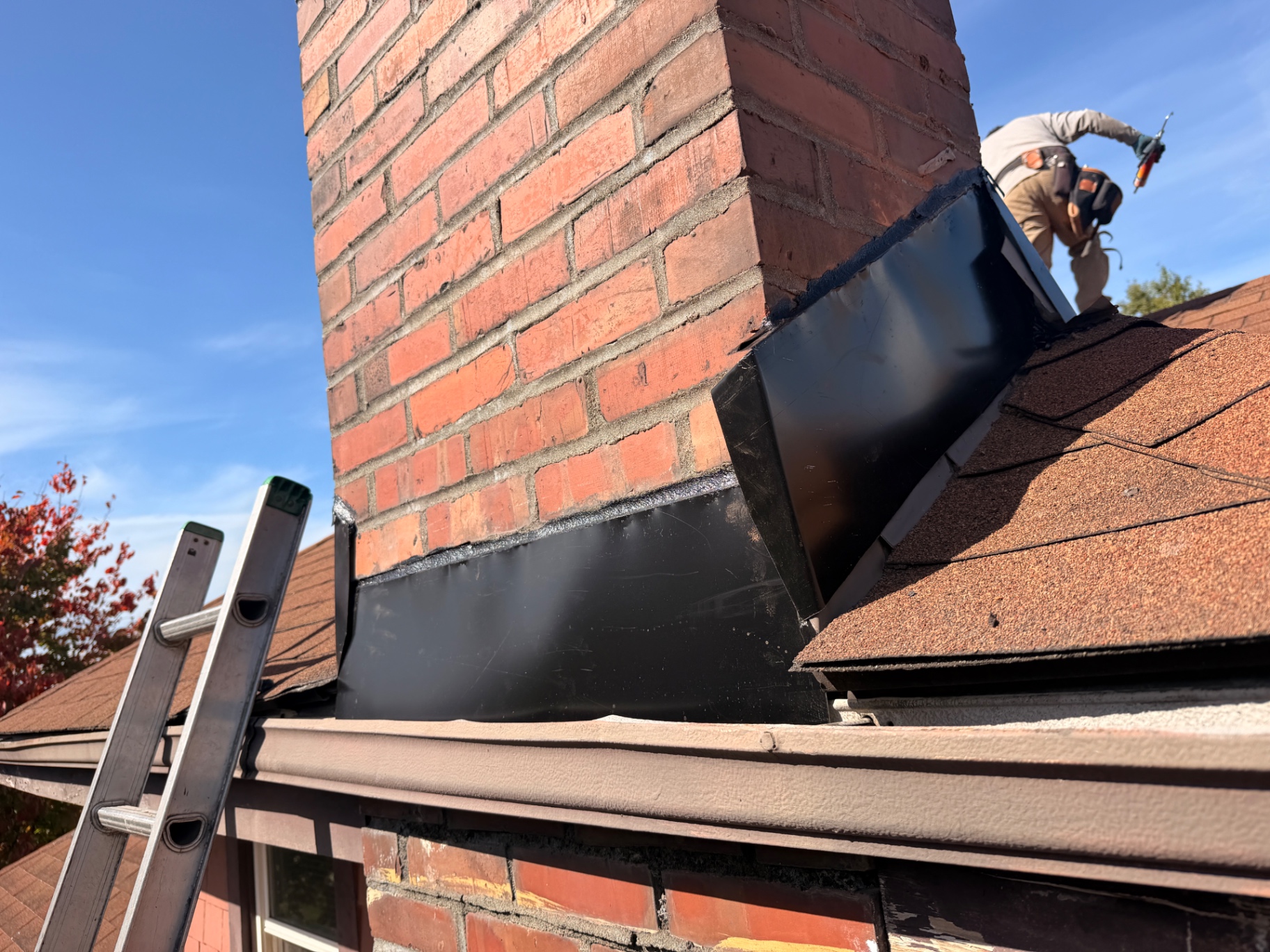New black chimney flashing installed during a roof leak repair