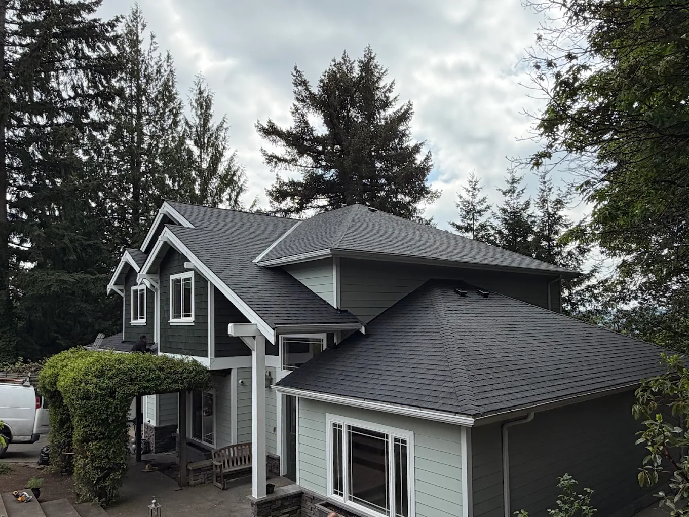 Freshly installed shingle roof under a blue sky